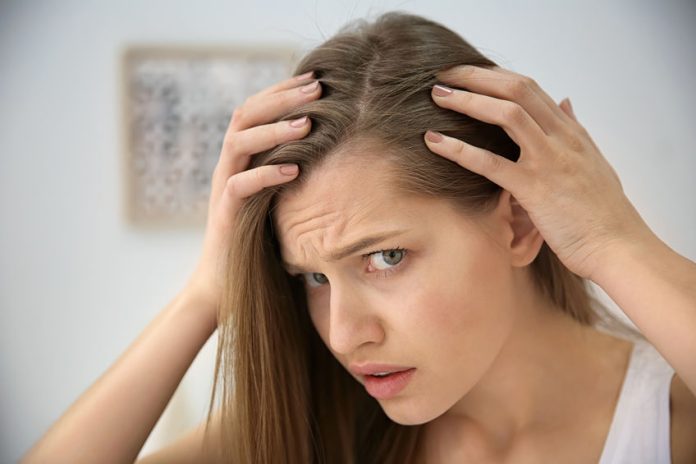 Young woman with hair loss problem indoors